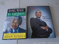 Front covers of both hardcover biography books: 'Long Walk to Freedom' by Nelson Mandela and 'Barack Obama' by Guy Saint-Jean.