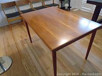 Table seen from low front corner angle with chairs in background