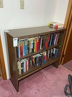 Front view of bookcase showing glass sliding doors and books inside