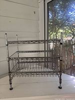 Front view of chrome three-tier shelving with two pull-out baskets installed