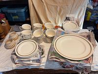 Full set: stacked plates, saucers, cups, cream and sugar bowls, oval platters wrapped in newspaper