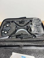 Drone, remote controller halves, spare propellers and battery inside foam case