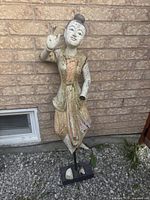 Full view of standing polychrome teak statue on base