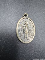 Front side showing Our Lady of Lourdes relief on oval medal
