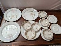 All porcelain pieces arranged: 4 large plates, 5 small plates, 6 bowls