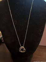 Full view of necklace on display bust showing chain length and pendant