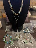 Full lot showing necklace on display bust, bracelet, earrings, pendants and hair ties