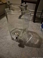 Glass beverage dispenser without lid on floor