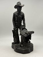 Full view of cowboy sculpture showing entire figure and base