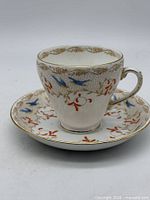 Teacup on saucer front view shows pattern and gilt rim