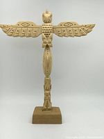 Full view of carved wooden Thunderbird totem on base