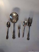 All five silverplate flatware pieces laid out for full view