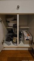 Cabinet view showing blender, rice cooker, food processor parts and boxed spiralizer
