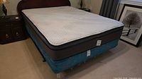 Full view of mattress on box spring with rails visible