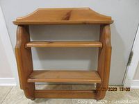 Front view of solid wood wall display shelf showing two interior shelves and pine finish