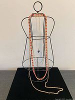 All five necklaces draped on display form