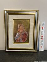 Full view of framed Madonna and Child artwork with ruler for scale