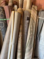 Group of rolled rugs showing the Aidas Montana rug among them