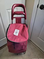 Front view of maroon shopping trolley with flap closed