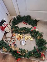 Garland coiled on floor with snowman and antler headbands visible