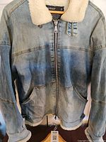 Front view of Vitaly denim jacket on hanger showing shearling collar, zipper, and pockets