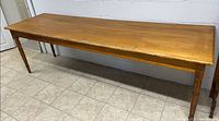 Top view of solid pine farmhouse dining table showing surface wear and honey finish