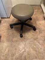 Side view of stool showing seat, base and casters