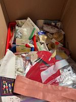 Box with assorted ribbons, trims, pom poms, googly eyes, straw hats