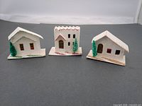 Front view of the three cardboard Putz houses on bases