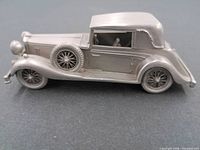Left side view of pewter 1936 Alvis Speed 25 model car showing side-mounted spare and convertible roof