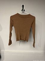 Front view of brown ribbed youth sweater on hanger