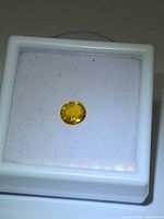 Yellow oval sapphire in white gem display box