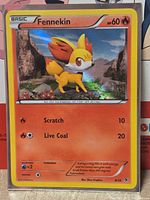 Front of sleeved Fennekin holographic card