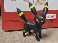 Front view of black Umbreon figure showing facial details and yellow markings