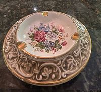 Top view showing floral centre, gold rests, raised scroll border