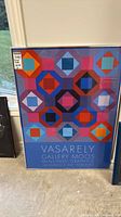 Full view of framed Vasarely poster leaning against wall