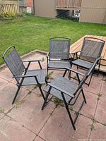 Four grey sling foldable patio chairs arranged on patio