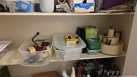wide view of shelf with bins of tapes, level, staple gun and rotating organizer