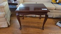 Front view of Gibbard end table showing cabriole legs and wood finish