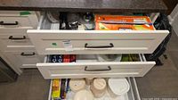 Upper and lower kitchen drawers showing foil boxes, storage containers, utensils