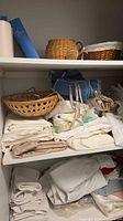 Shelved linens and two wicker baskets visible