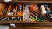 Drawer view showing flatware, wine funnel, candle holders, Halloween candles, lighters