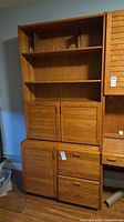 Full view of tall oak hutch showing shelving, cabinet doors, drawers