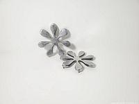 Two cast aluminum flower trivets angled view