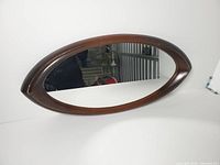Front view showing cat’s-eye walnut-finish frame and glass