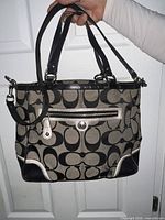 Front view of Coach signature jacquard tote with handles and shoulder strap visible