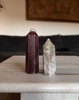 Front view of both crystal towers standing on flat surface, showing color and shape