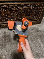 Side view showing metal frame, orange handle, tension knob