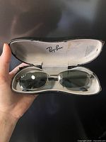 Sunglasses resting in open Ray-Ban hard case, full view