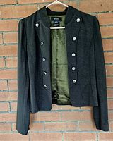 Front view of dark green double-breasted jacket showing buttons and collar